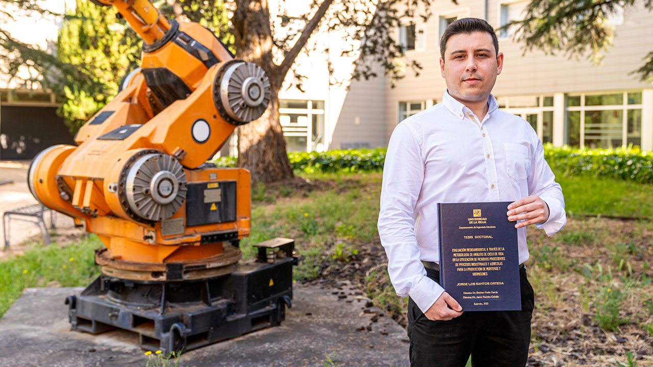 El doctor Jorge Los Santos Ortega posa con el volumen de su tesis en el patio de la Escuela Técnica Superior de Ingeniería Informática