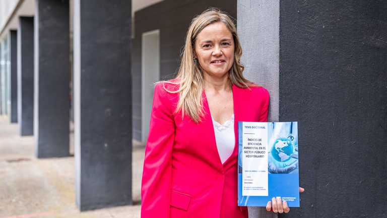 La doctora Vanesa Jiménez Lacarra posa con el volumen de su tesis