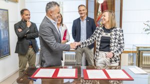 Conrado Escobar y Eva Sanz se saludan tras la firma del convenio en presencia de Eduardo Fonseca, Cristina Olarte y Miguel Sainz