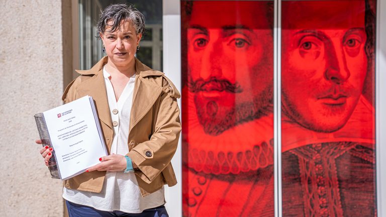 Begoña Ayala Pagola posa con el volumen de su tesis a la entrada del Edificio Filología
