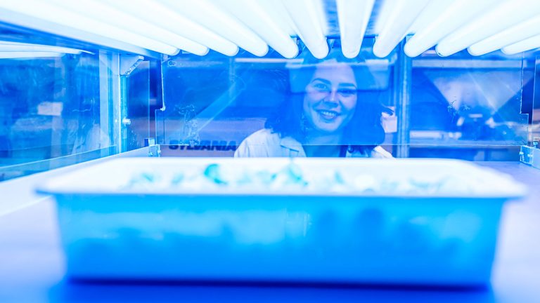 Raquel Hidalgo Sanz, al fondo de la imagen, tras una maquína de radiación UV-B utilizada durante su investigación doctoral